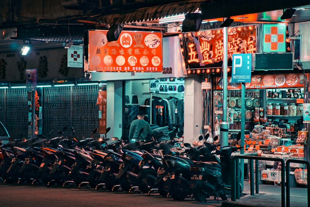 a man standing in front of a store filled with motorcycles