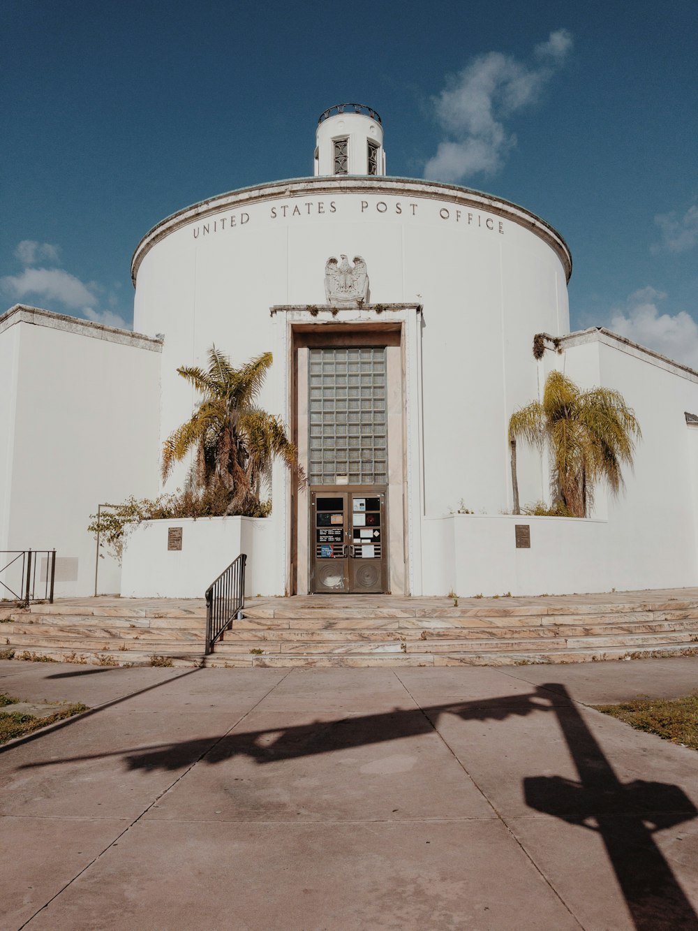 a large white building with palm trees in front of it