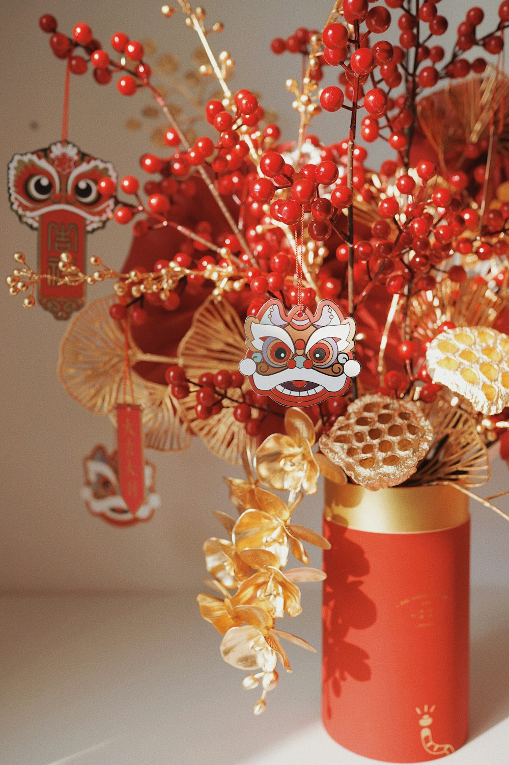 a red vase filled with lots of red berries