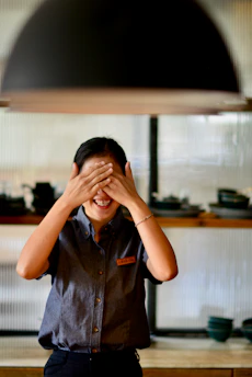 a woman covering her eyes in a kitchen