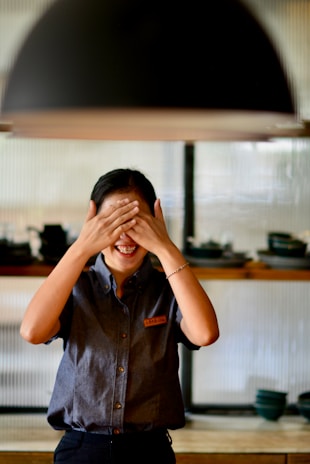 Smiling customer standing next to a newly installed kitchen chimney duct in a bright kitchen.