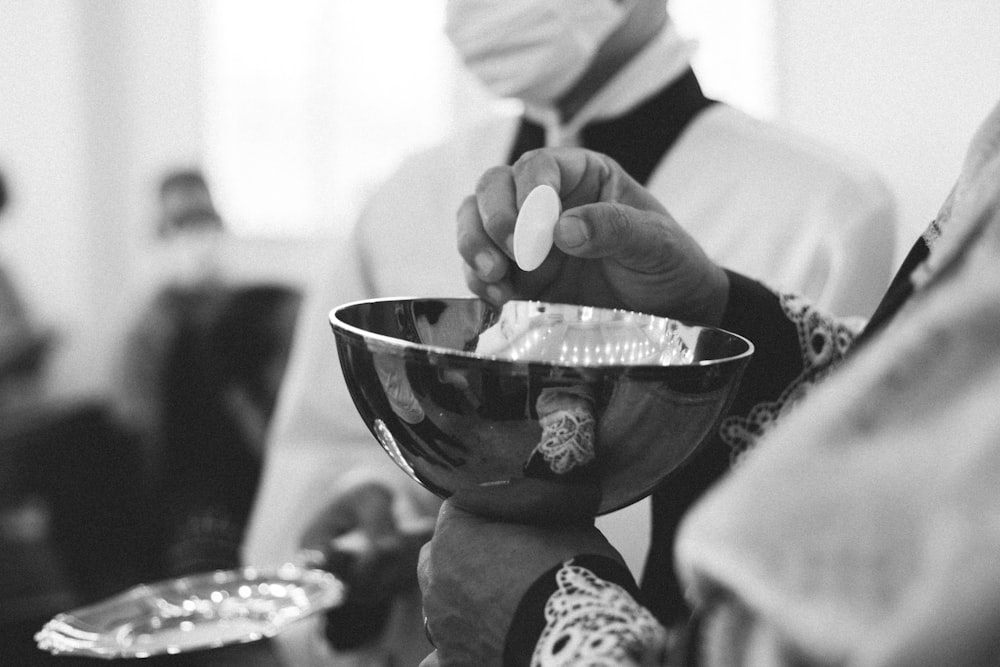 a person in a face mask is holding a bowl