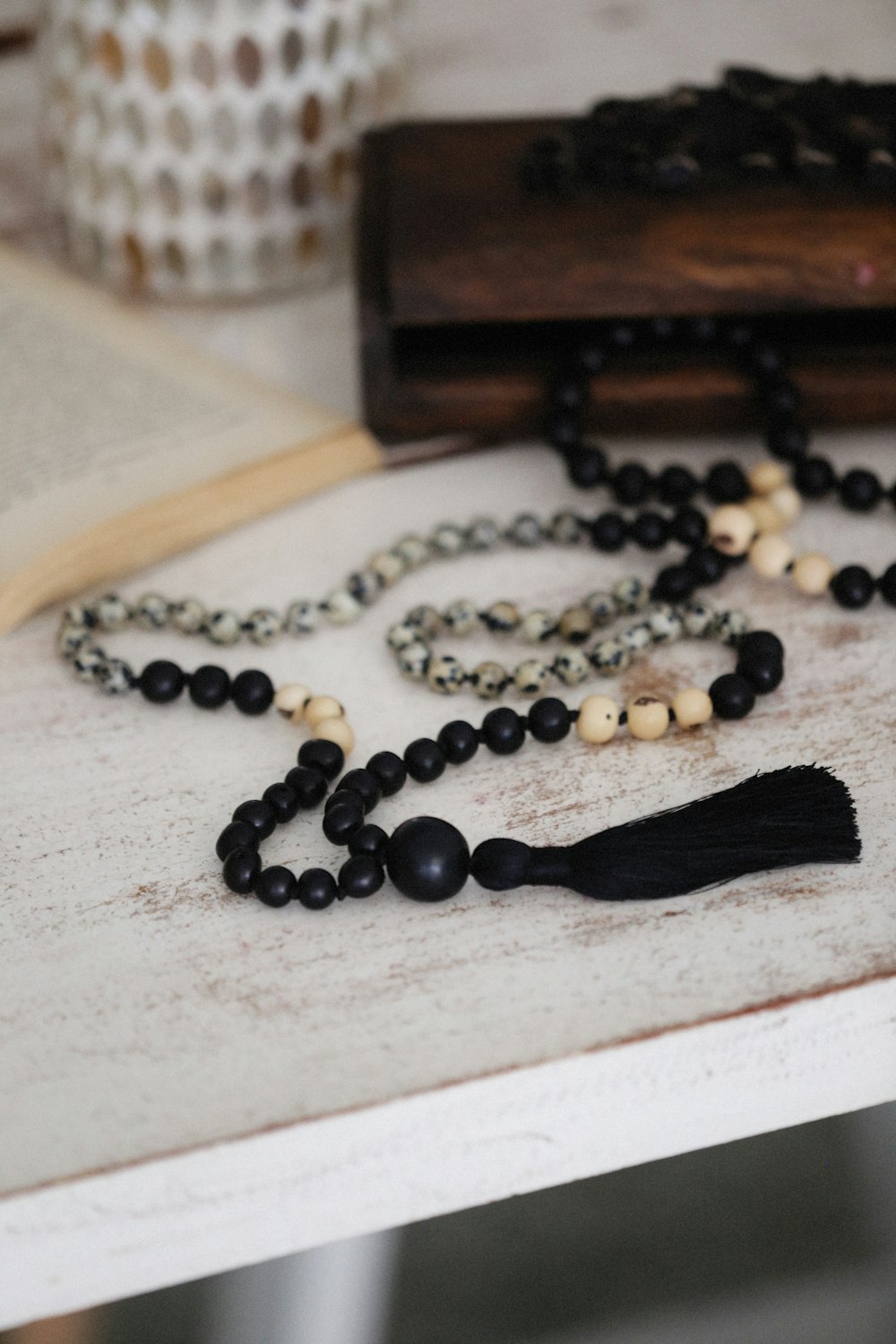 a rosary with a black tassel on a table