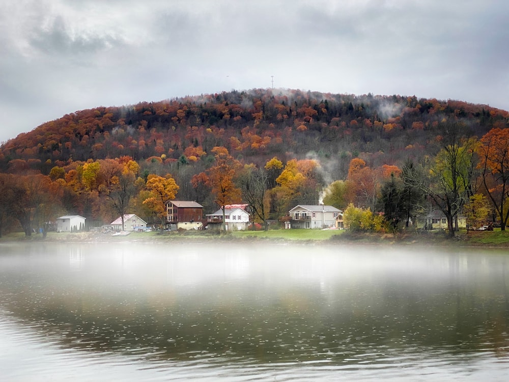 a body of water with houses on a hill in the background