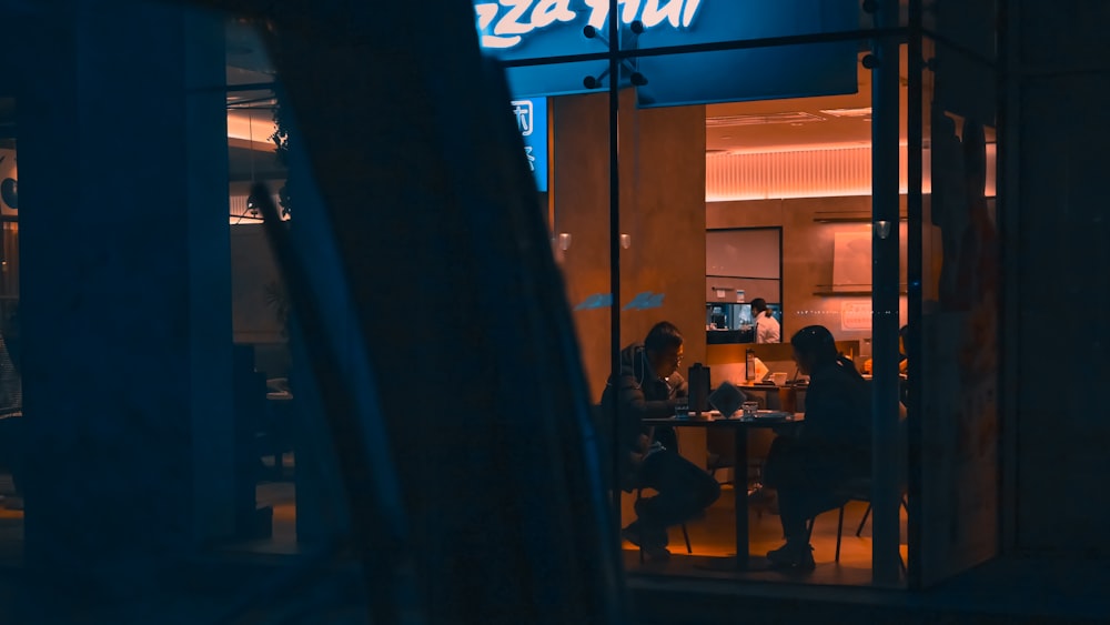 Un grupo de personas sentadas en una mesa fuera de un restaurante