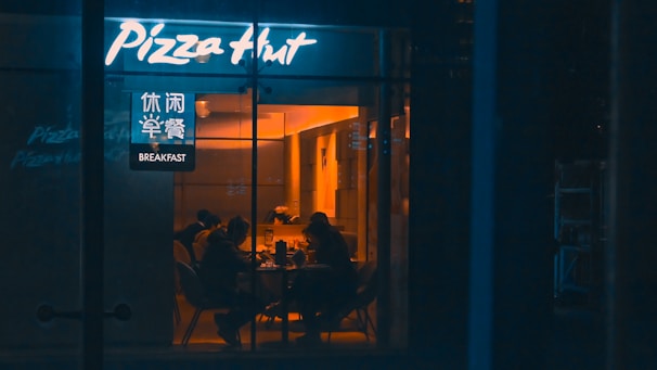 a group of people sitting at a table outside of a restaurant