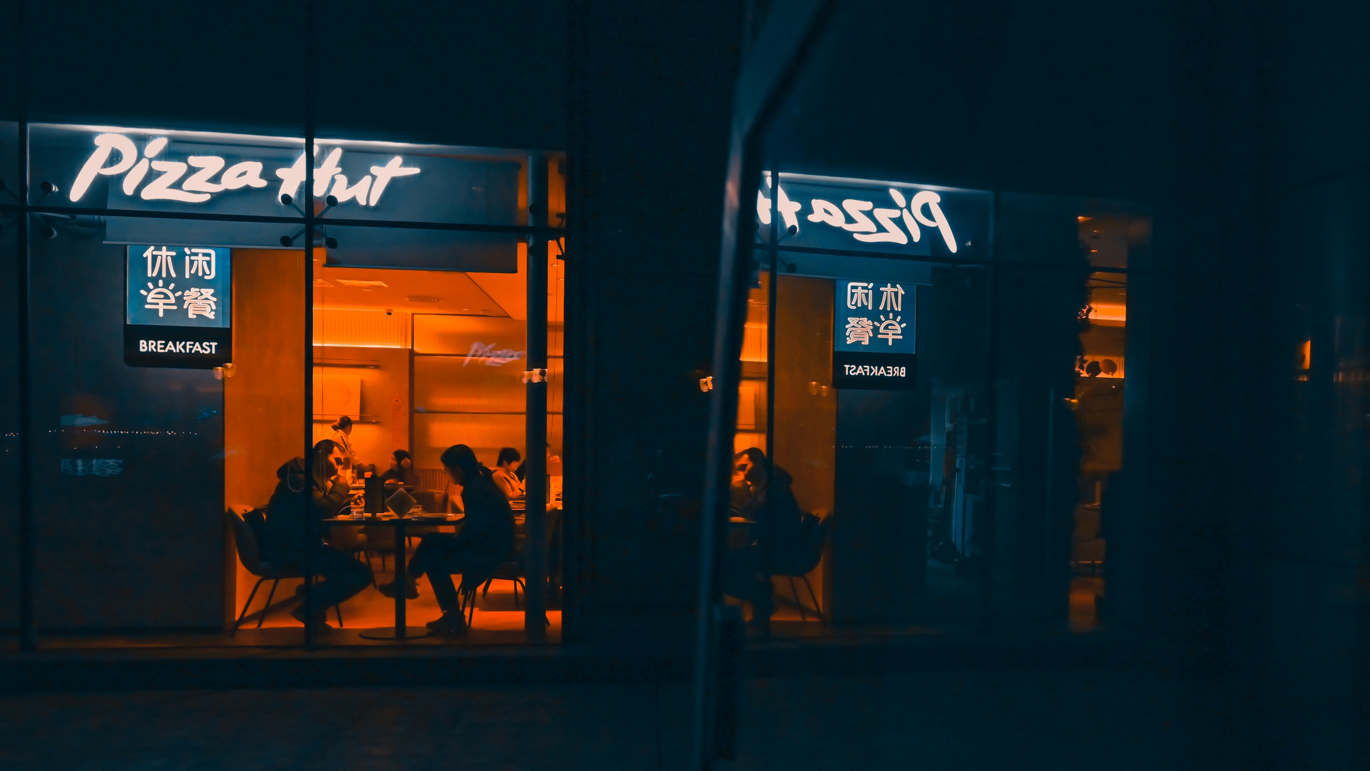 a group of people sitting at a table outside of a restaurant
