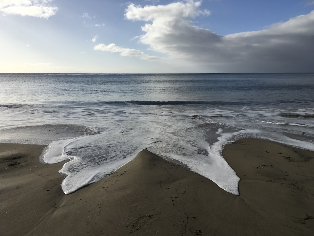 a view of the ocean from a sandy beach