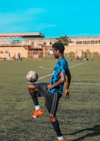 Close-up of a player skillfully dribbling the ball on a sunny football pitch