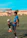 Smiling young man kicking a soccer ball on a sunny neighborhood field