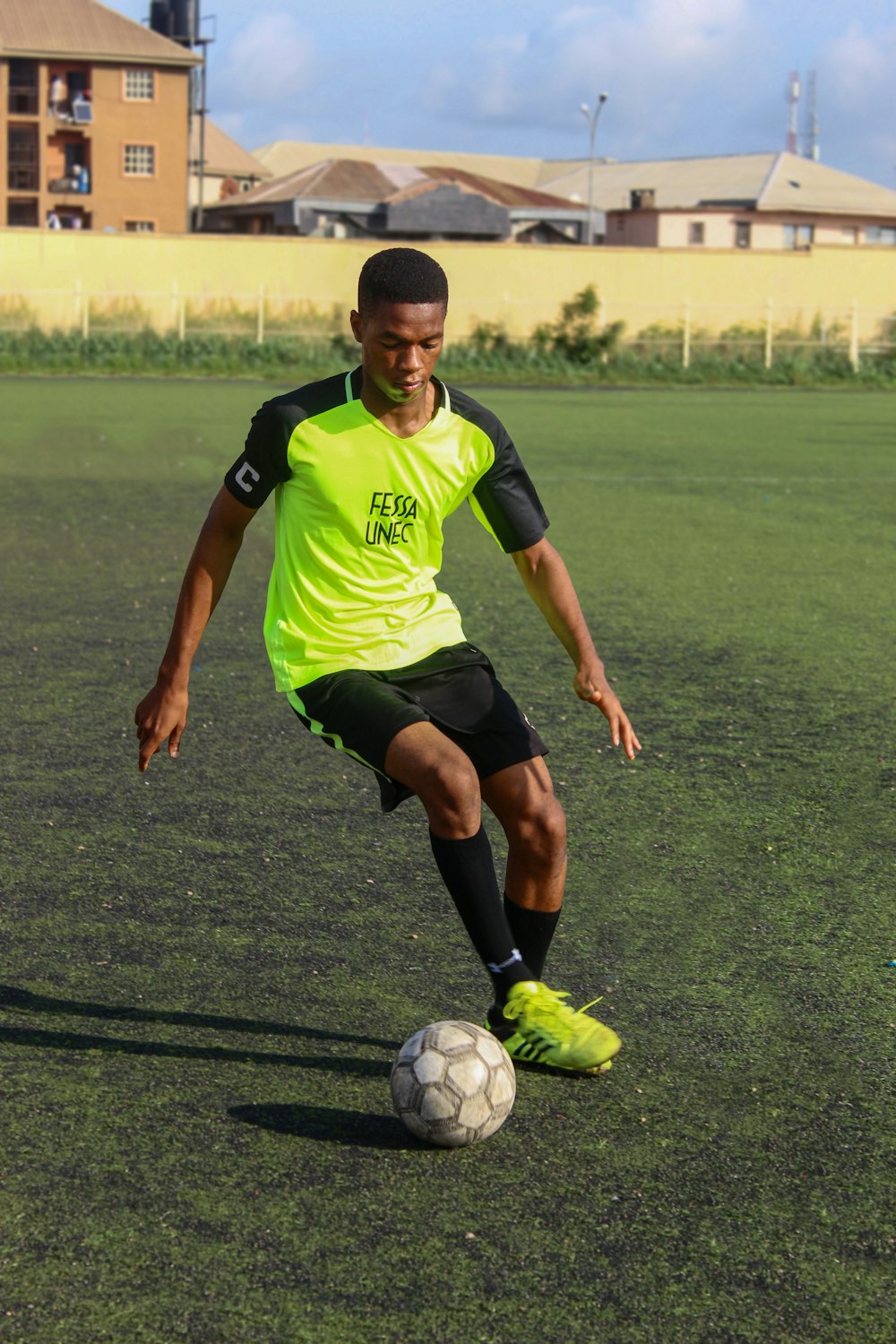 a young man kicking a soccer ball on a field