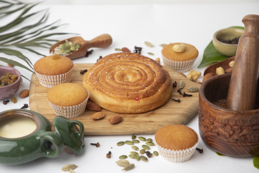 Foto Uma tábua de corte de madeira coberta com muitos cupcakes – Imagem de  Alimento grátis no Unsplash