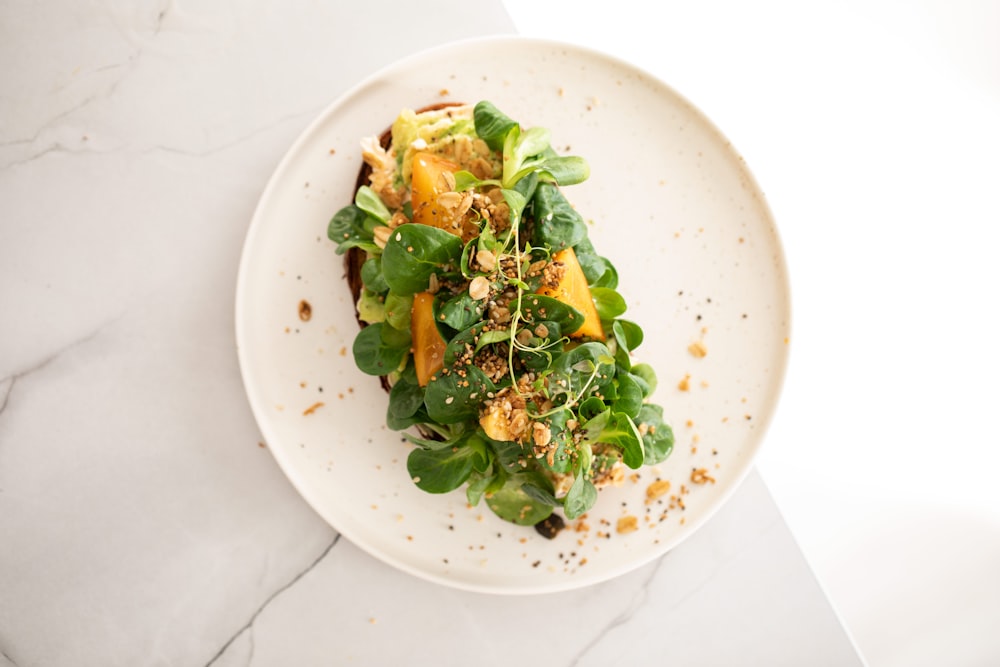 a white plate topped with a green salad