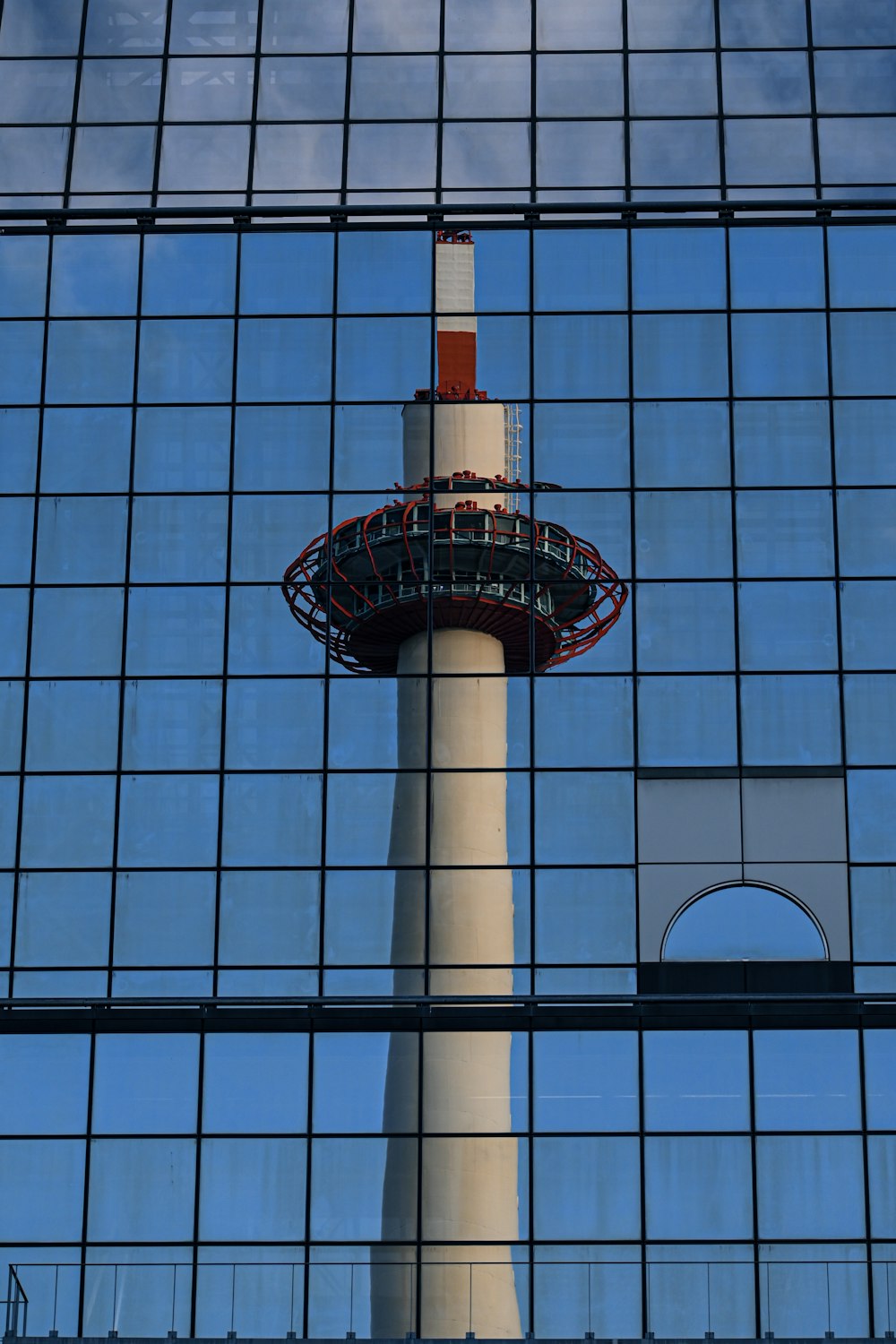 Spiegelung eines Turms in einem Glasgebäude