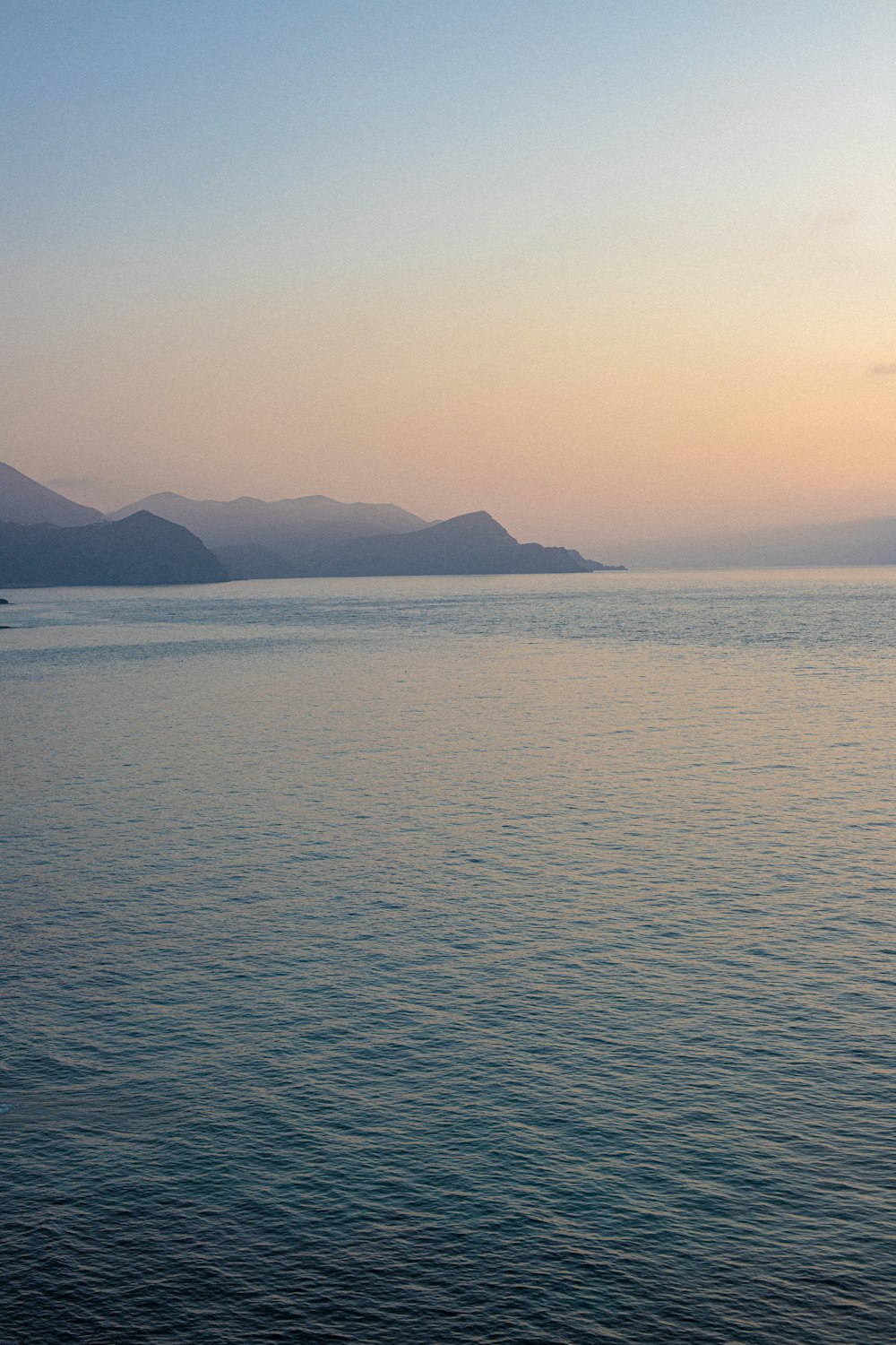 a large body of water with mountains in the background