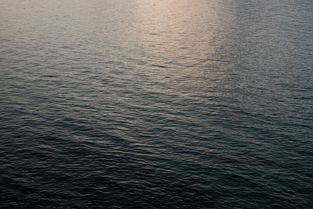 a large body of water with a boat in the distance