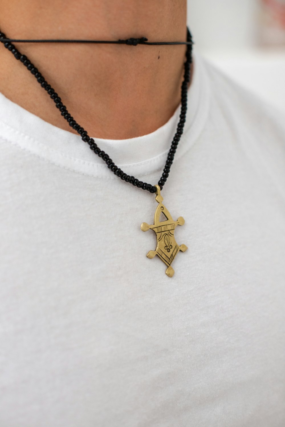 a man wearing a necklace with a cross on it