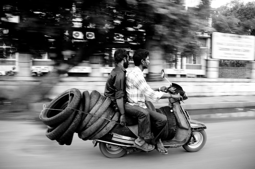 a man and a woman riding on the back of a motorcycle