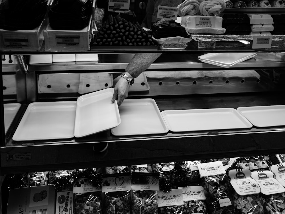 a black and white photo of a person picking up food