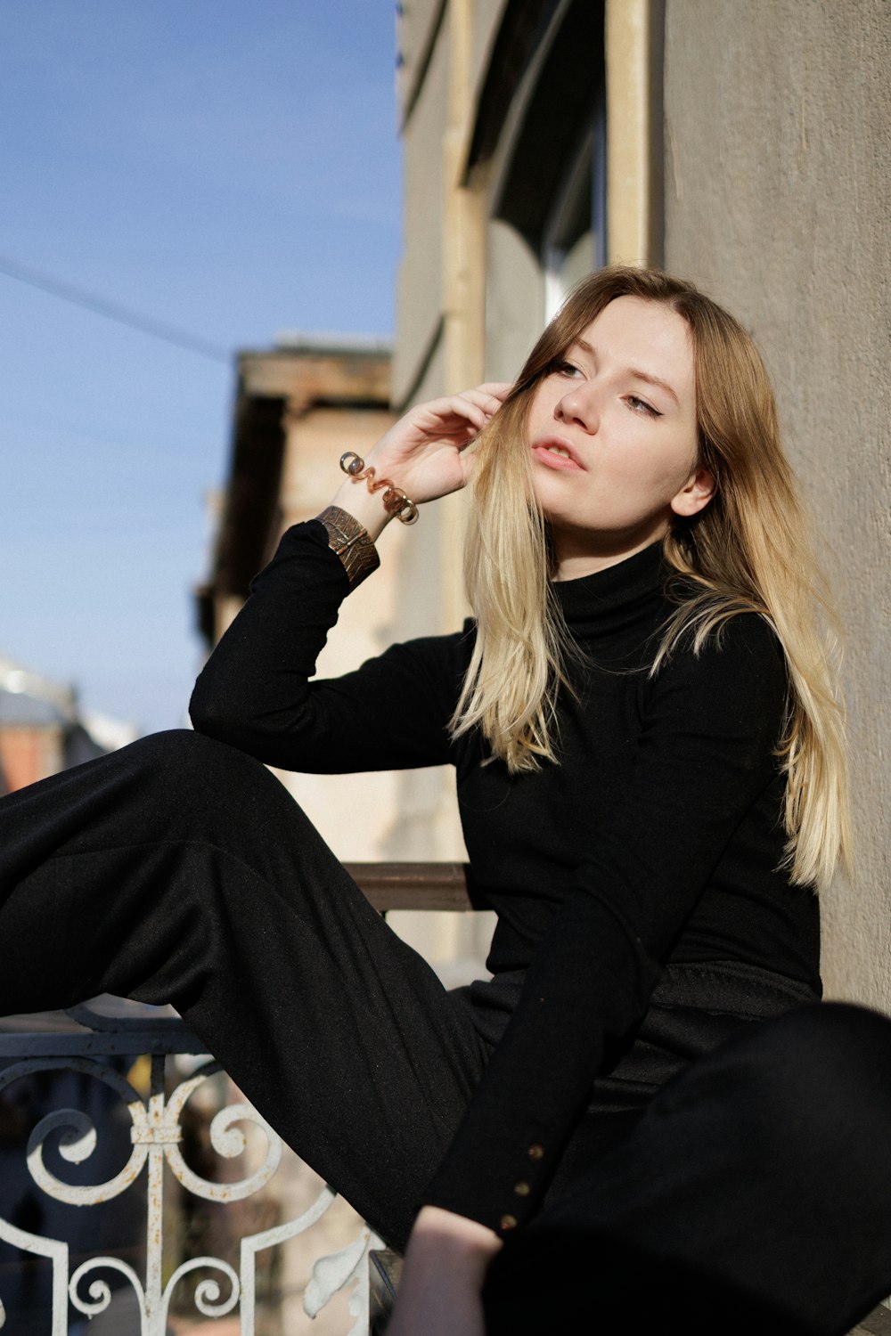 a woman sitting on top of a wooden bench