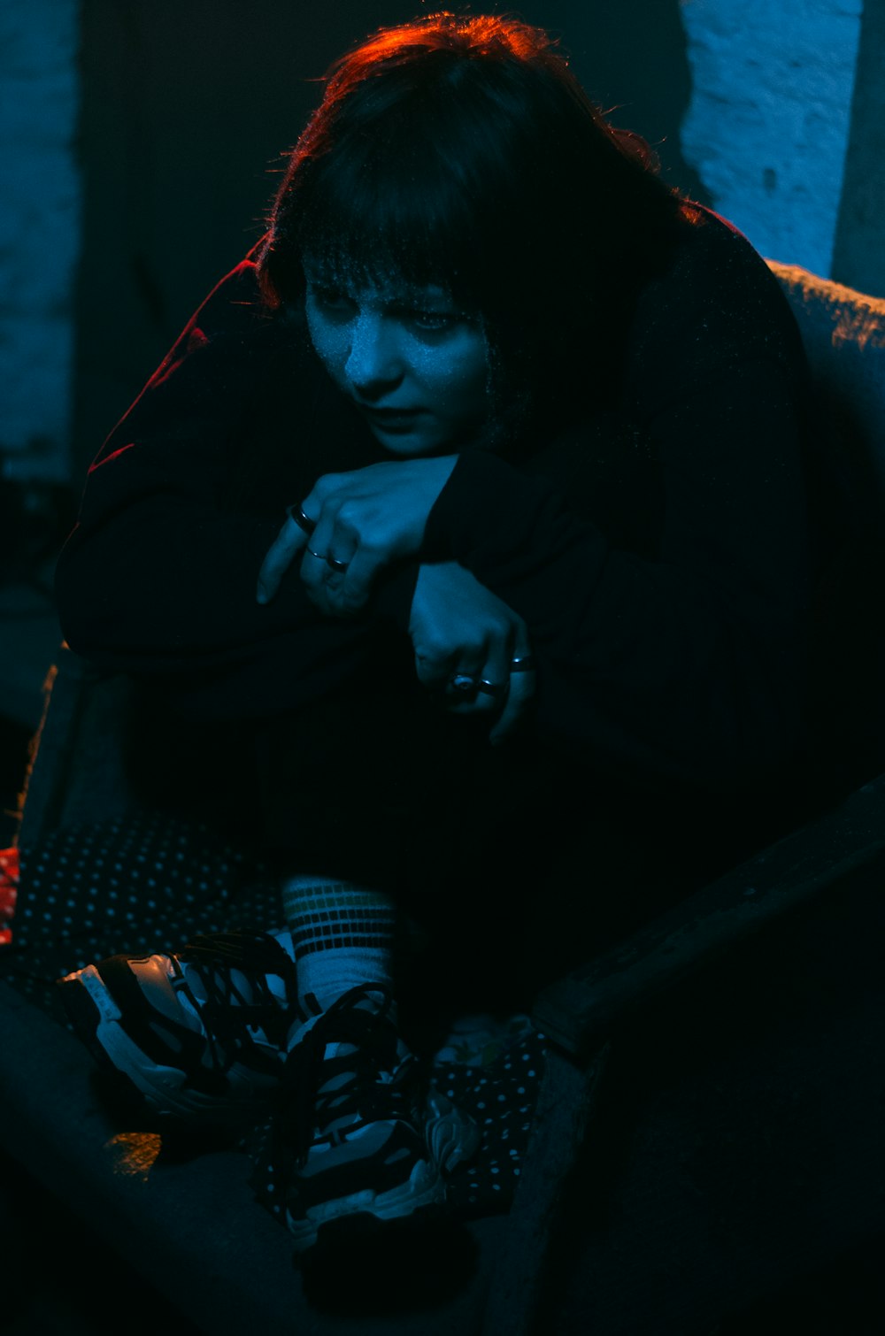 a woman sitting on a couch in a dark room