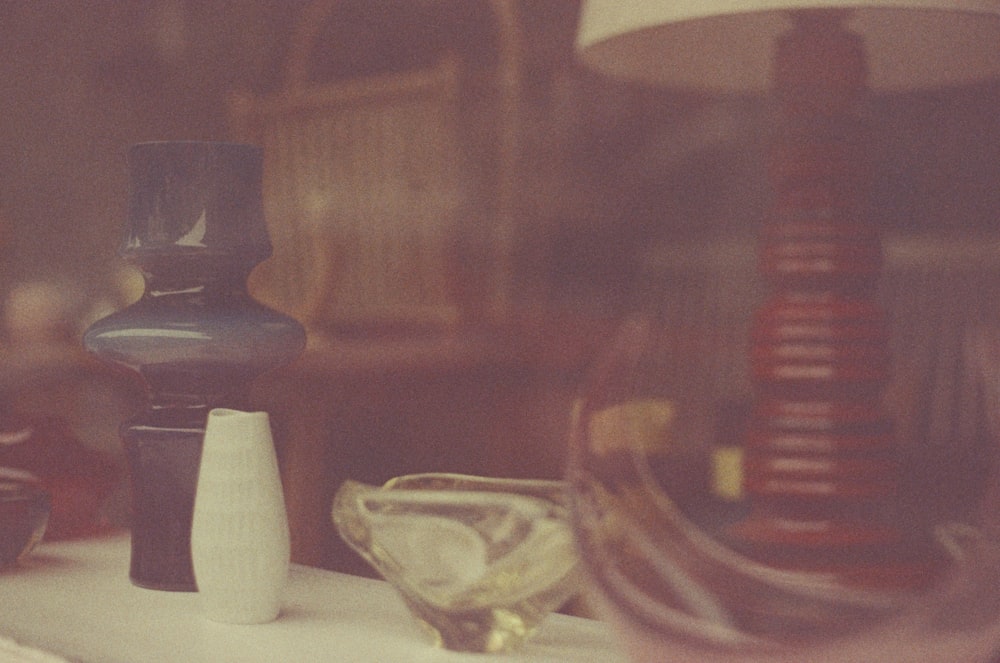 a table topped with a lamp next to a vase