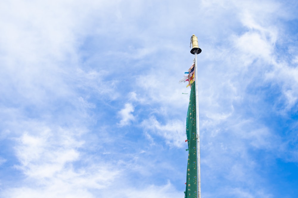a tall green pole with a flag on top of it