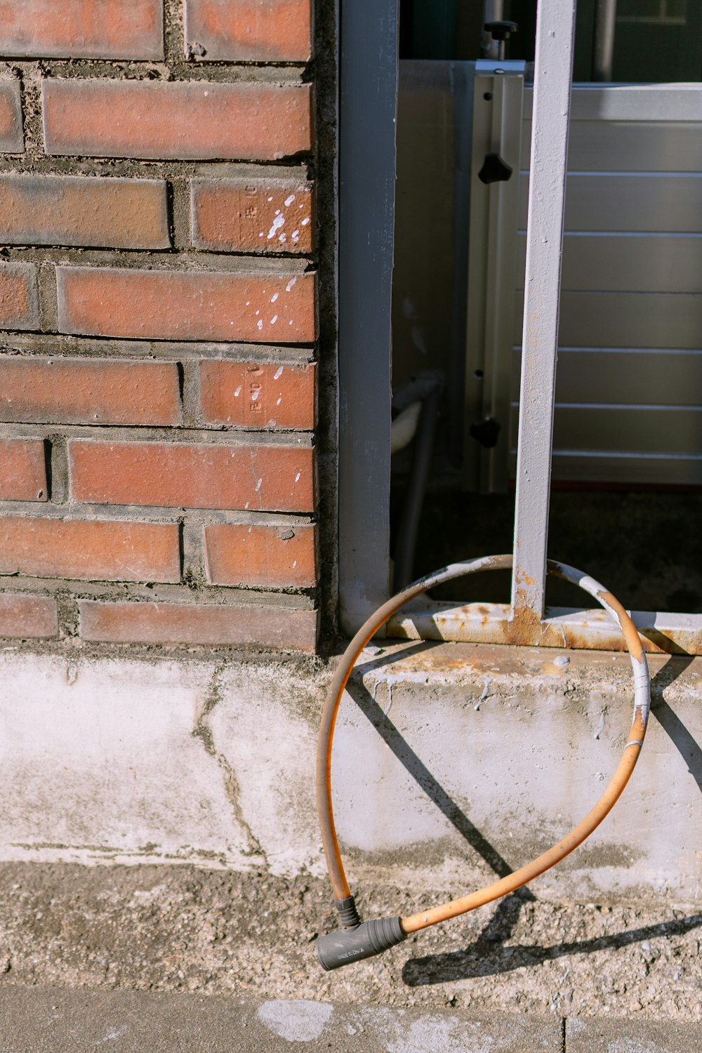 Ein kaputter Hydrant sitzt vor einem Backsteingebäude