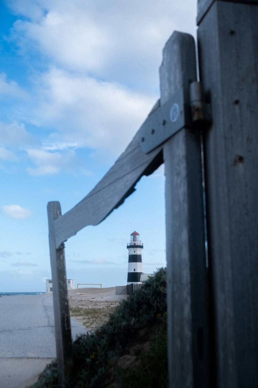 a wooden fence with a lighthouse in the background