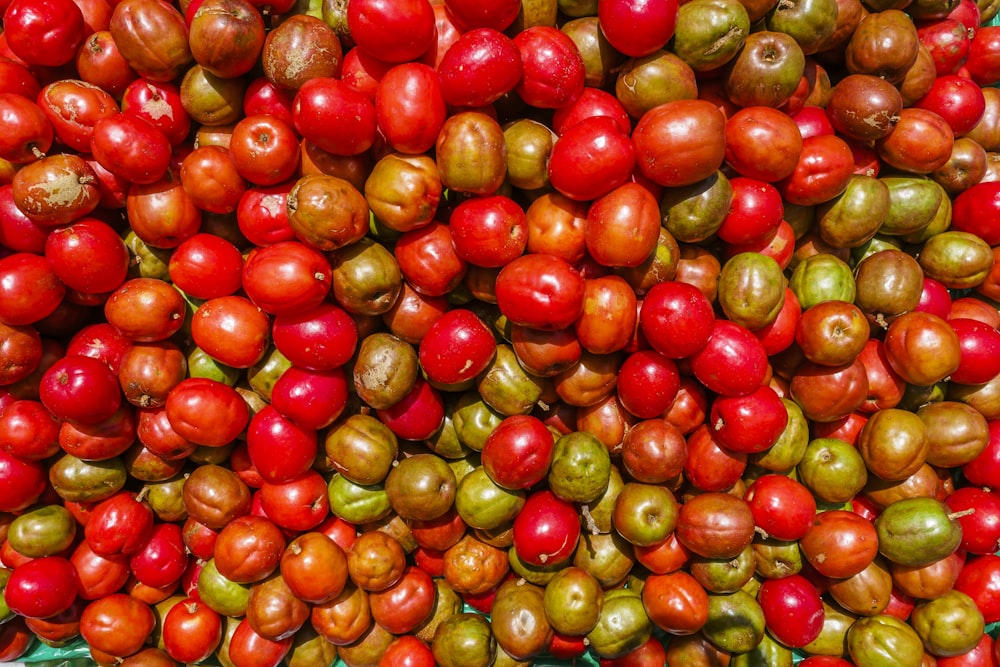 a pile of tomatoes and other fruits and vegetables