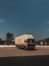 a large truck driving down a road under a blue sky