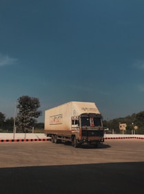 a large truck driving down a road under a blue sky