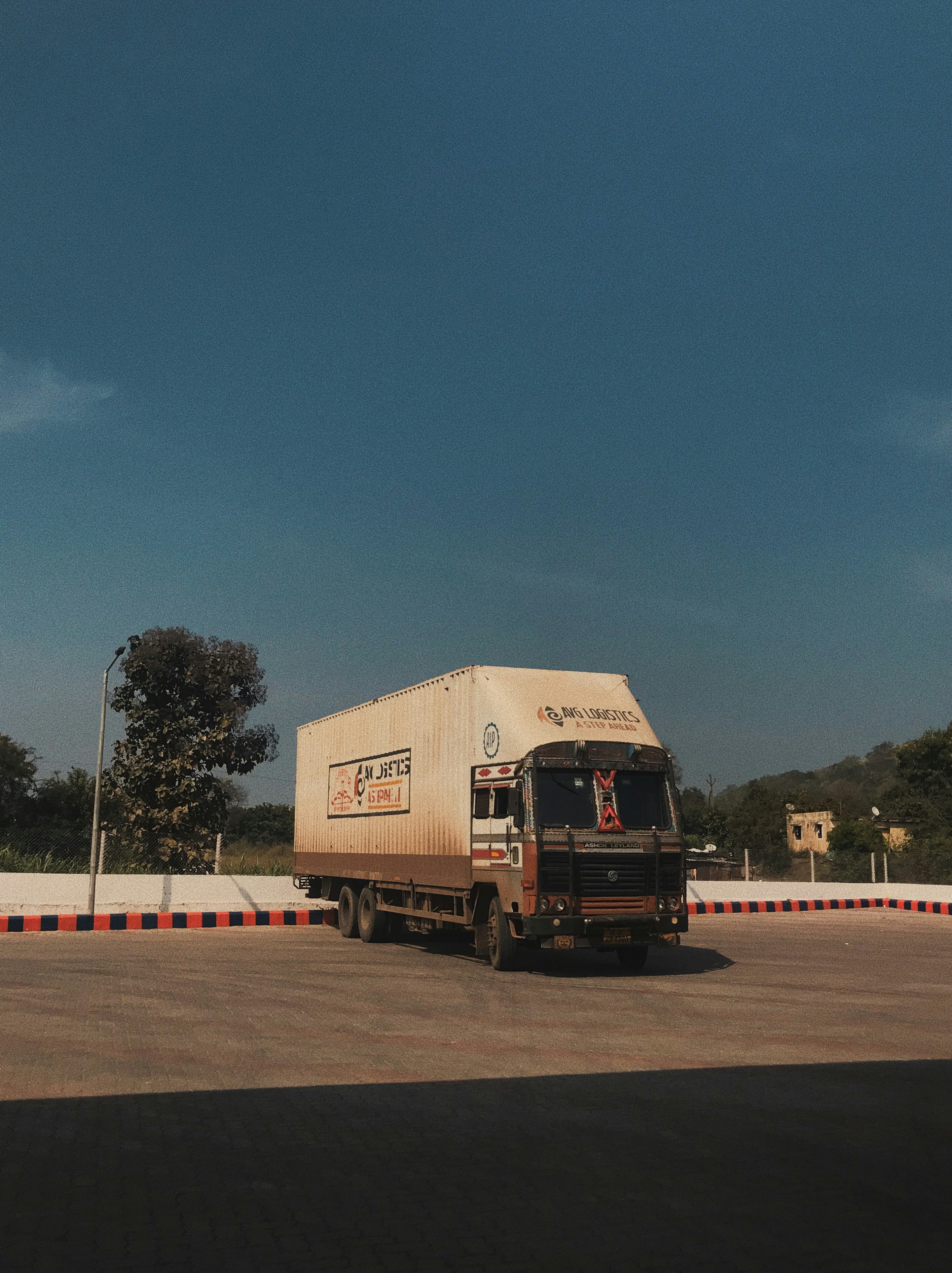 a large truck driving down a road under a blue sky