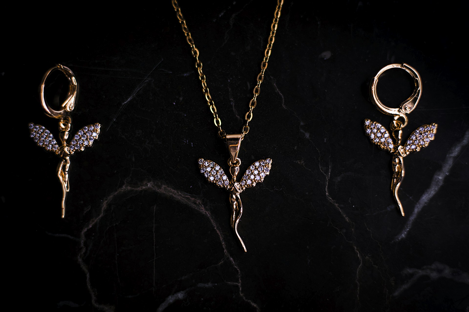 three pieces of jewelry on a black surface