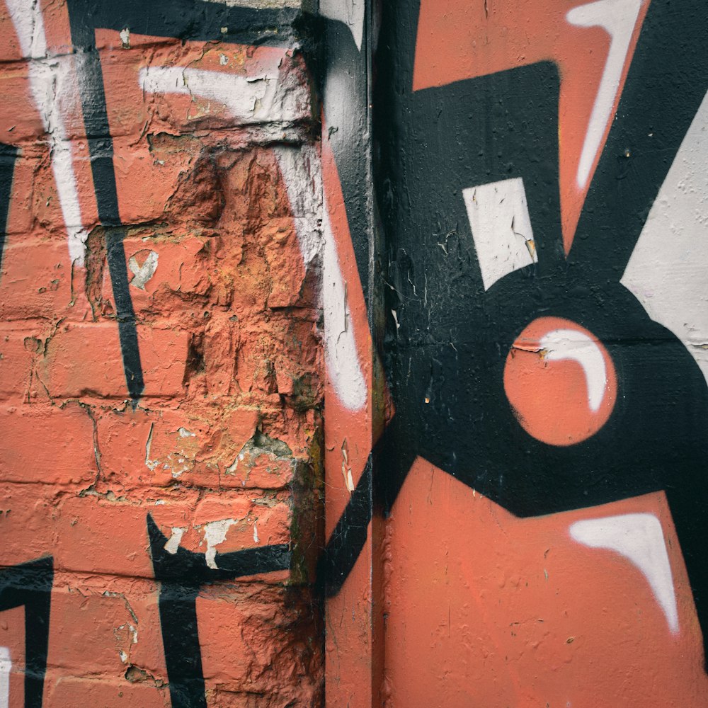 a red brick wall with black and white graffiti