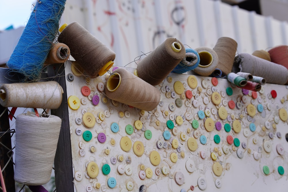 a bunch of spools of thread are hanging on a wall