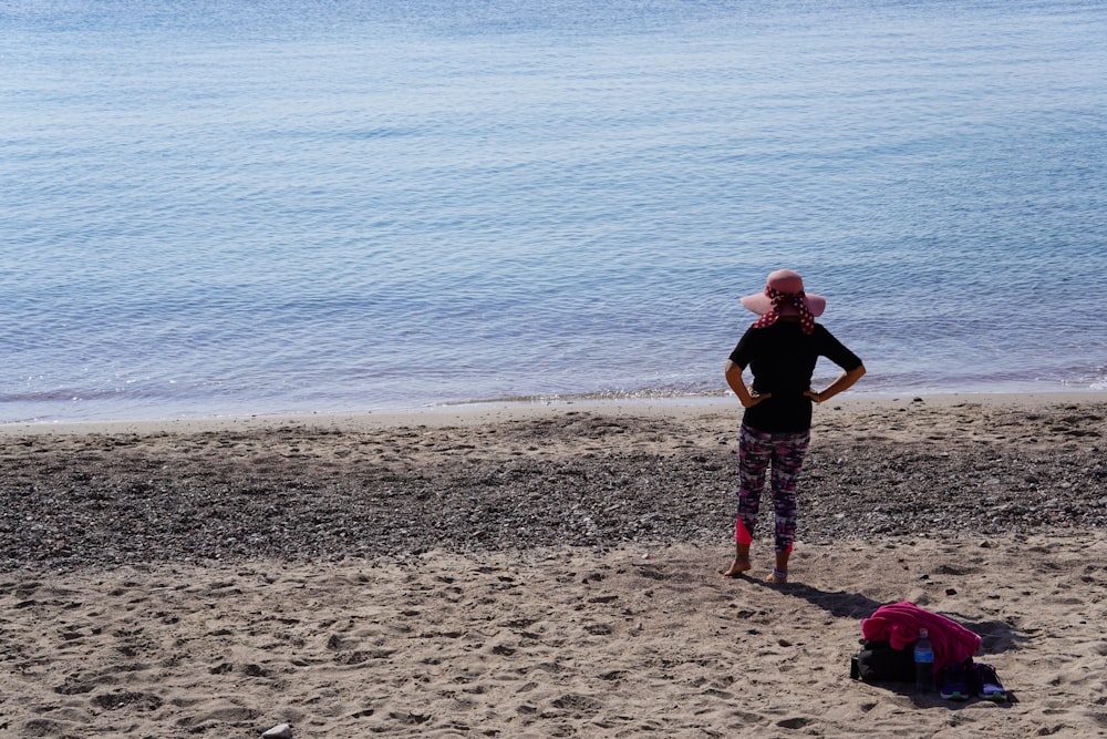 a woman standing on top of a sandy beach