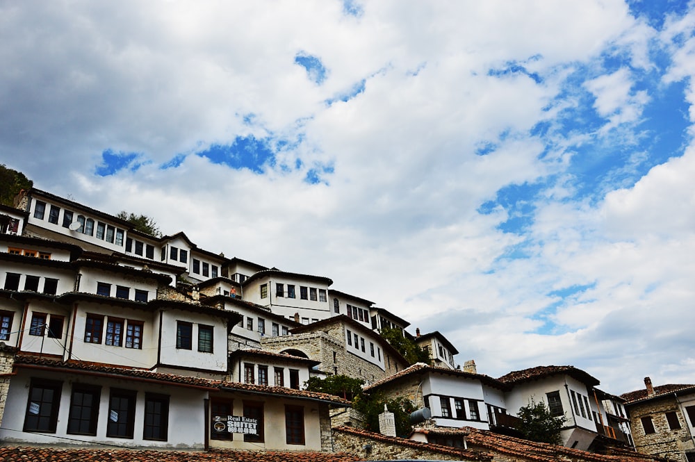 a row of houses on a hill under a cloudy sky