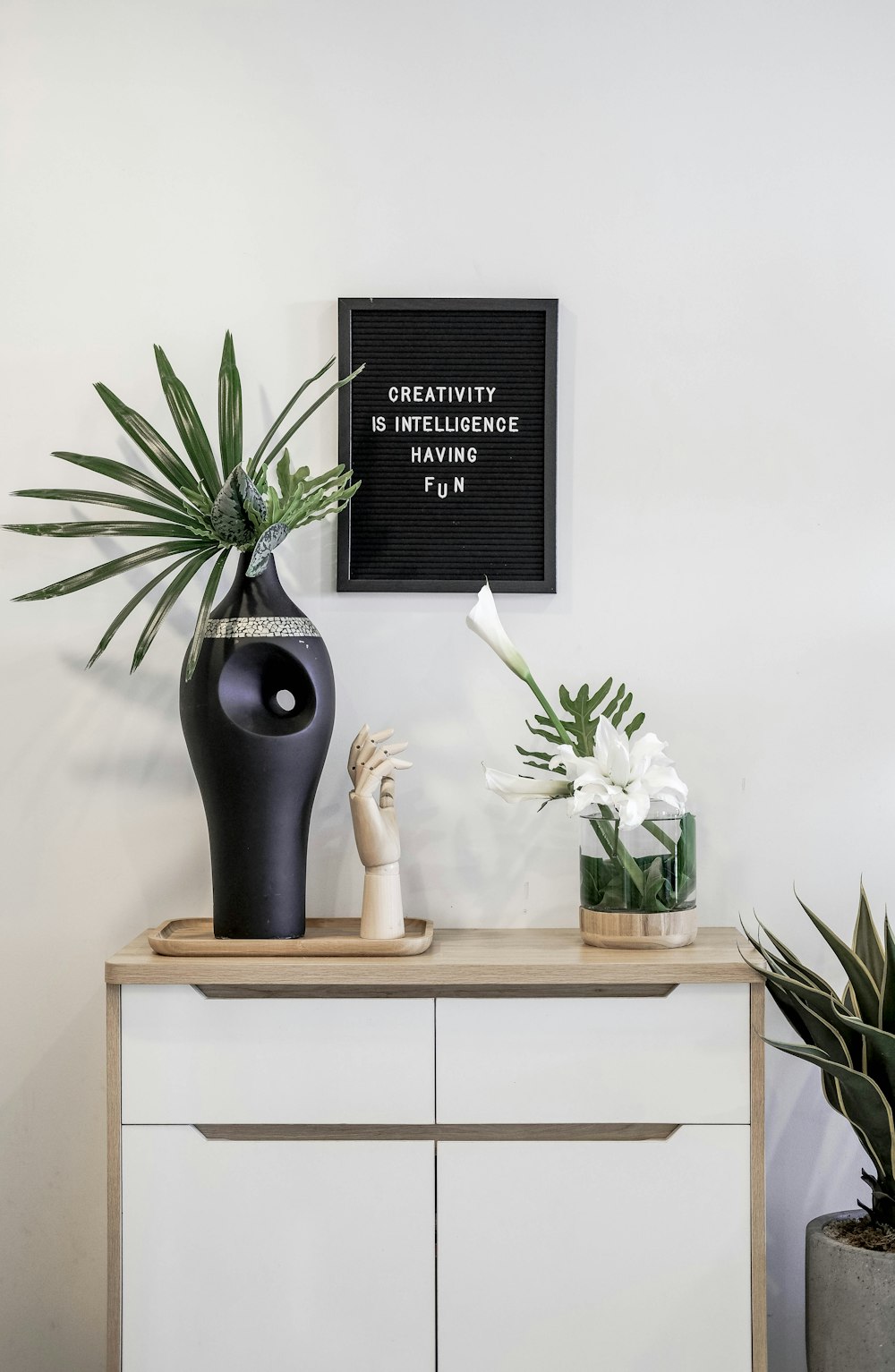 a black vase sitting on top of a white dresser