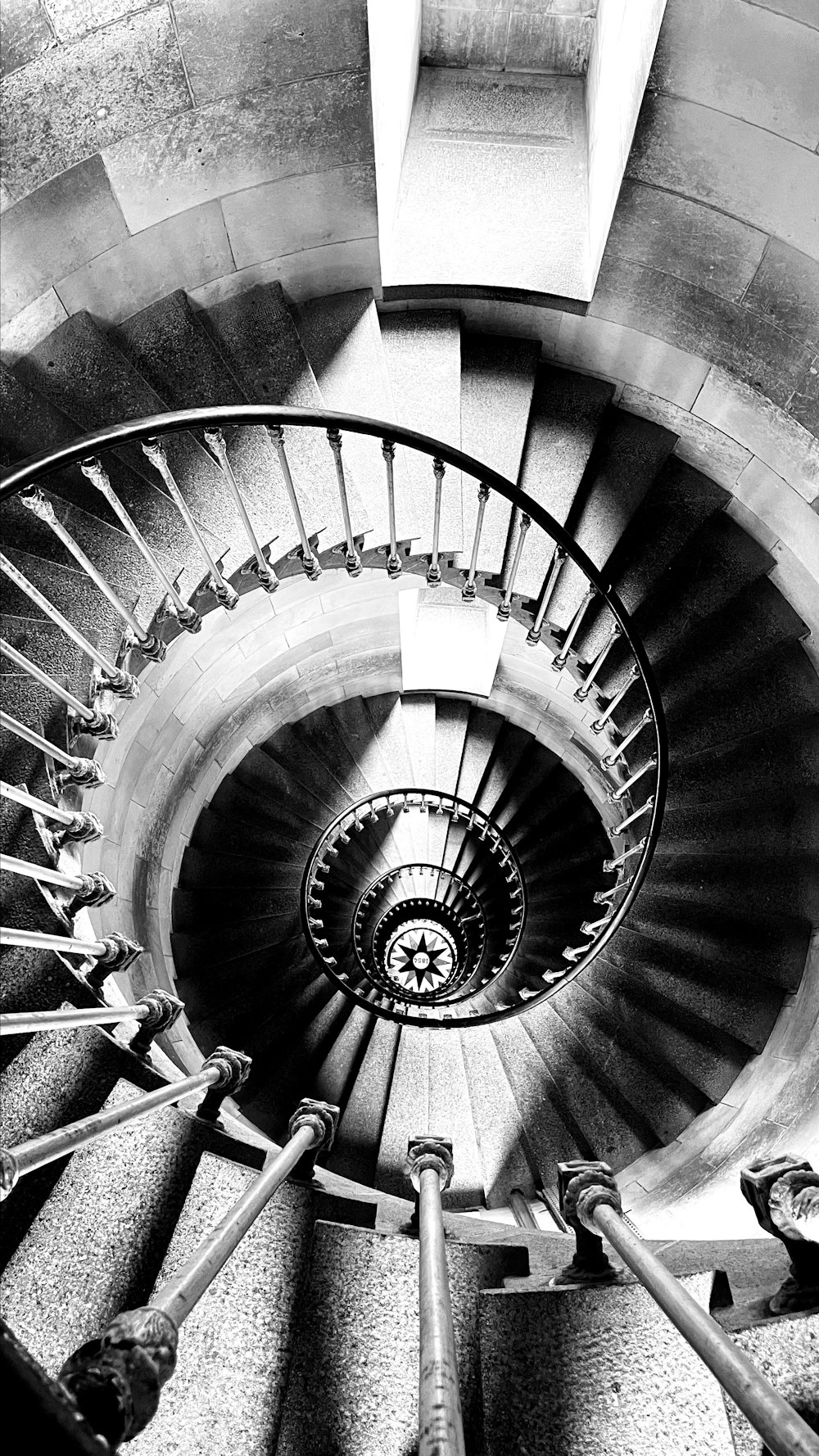 a black and white photo of a spiral staircase