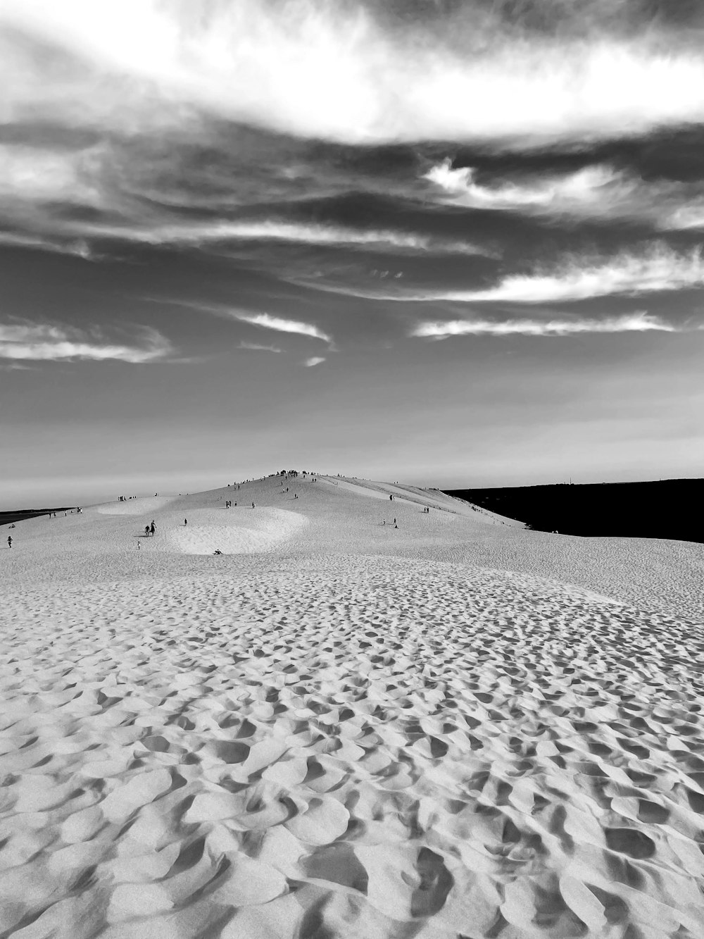 a black and white photo of a sand dune