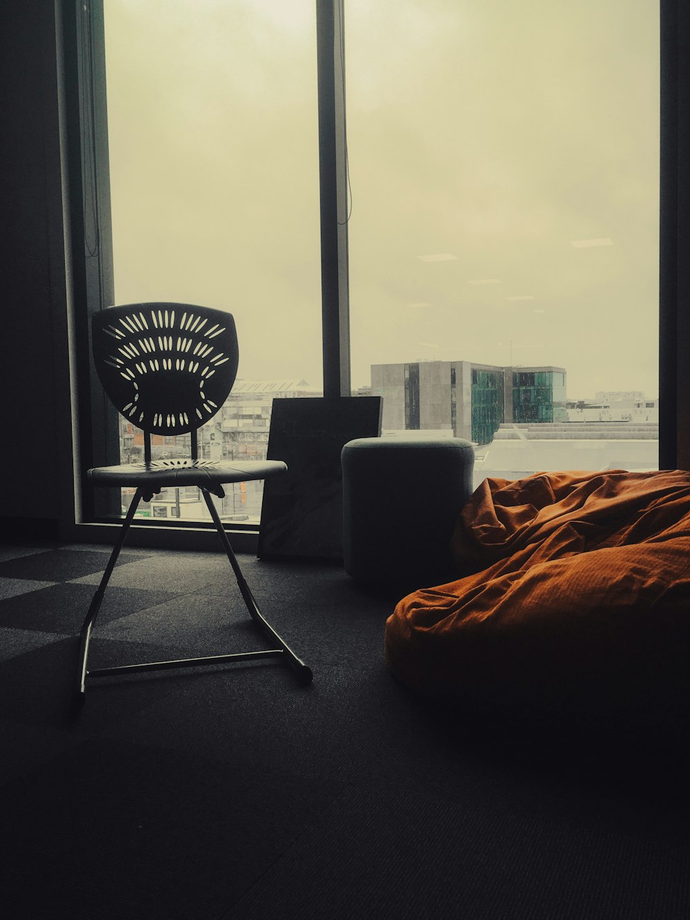 a chair sitting in front of a window next to a bed