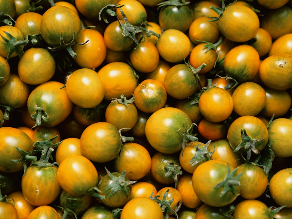 a bunch of tomatoes that are yellow and green