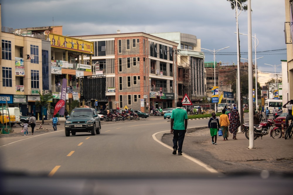 a group of people walking down a street next to tall buildings