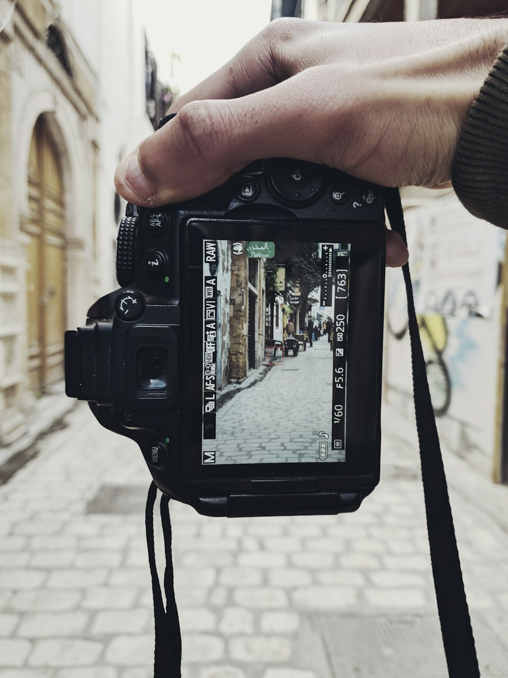 a person holding a camera on a street