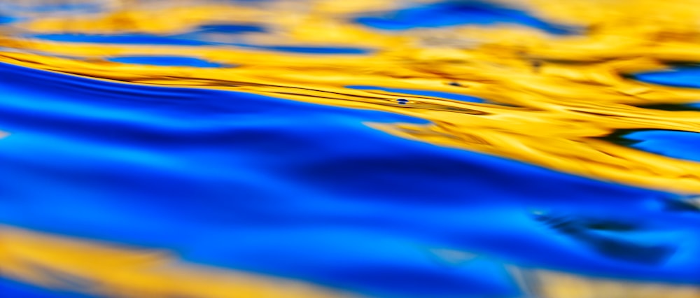 a close up of a blue and yellow water surface