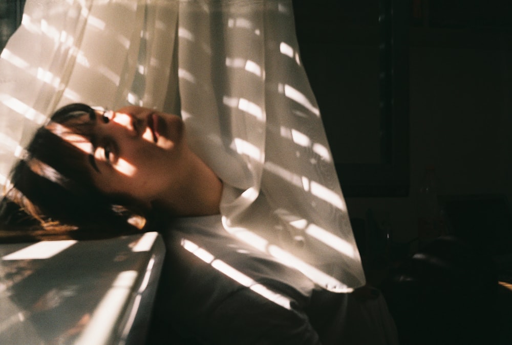 a woman laying in a hammock with her eyes closed