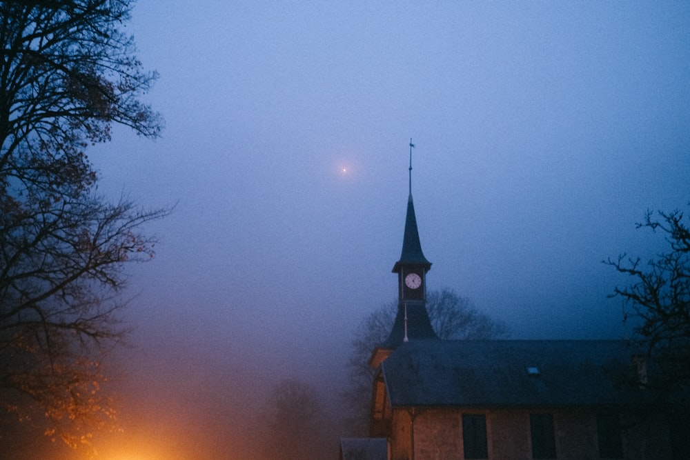 uma igreja com uma torre do relógio em um dia nebuloso