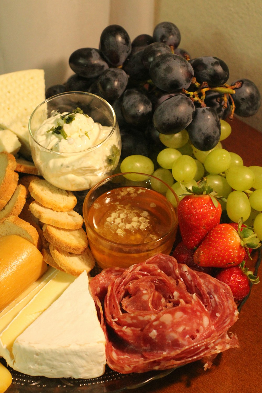 a platter of cheese, crackers, fruit, and crackers