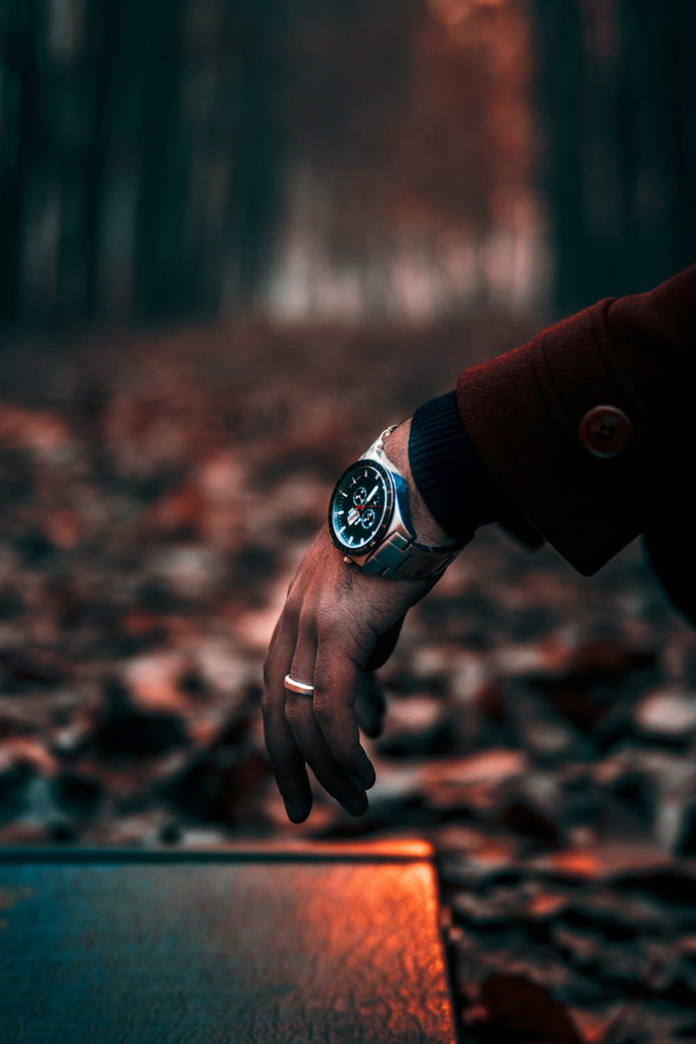 a person holding onto a watch in a forest